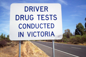Straßenschild in Australien mit der Aufschrift Driver Drug Tests conducted in Victoria