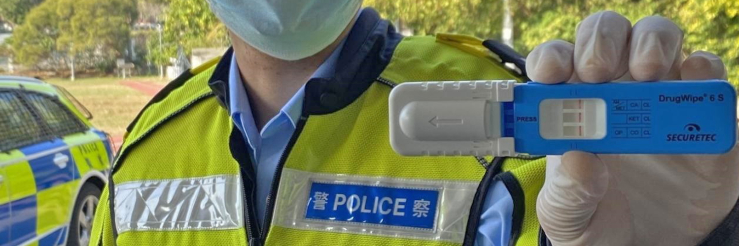 Polizist in Hongkong hält Drogenschnelltest DrugWipe hoch