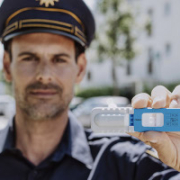Ein Polizist hält den blau-weißen Drogenschnelltest DrugWipe vor die Kamera
