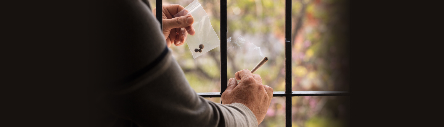 drogennachweis-kriminaltechnik-3-1 Hand mit einer Zigarette vor einem Fenster mit Gittern
