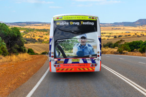 Australische Landschaft mit Bus der Highway Patrol und Aufschrift Mobile Drug Testing