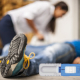 Eine Mann liegt ohnmächtig am Boden und eine Kollegin spricht ihn an. Im Vordergrund ist der Drogenschnelltest DrugWipe zu sehen.